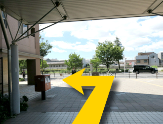 駅を出て左に進んでください。
